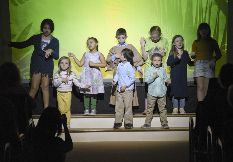 Children sing a worship song. Shown are (l-r in back) Michelle Rocha, Marissa Hurley, Ian McNally, Kristen Spiezio, Phoenix Mullin, Lyra Mullin. In front are (l-r) Violet Mullins, Camden McNally, Jayson Canedy.